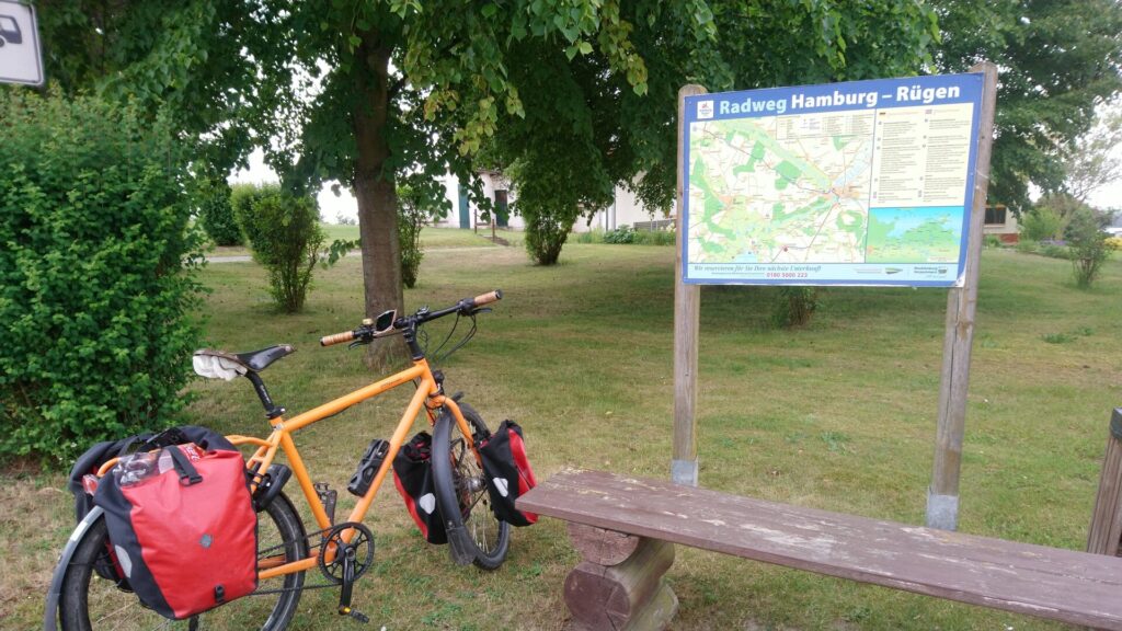 Fahrrad vor einer Tafel mit einer Karte "Radweg Hamburg - Rügen"